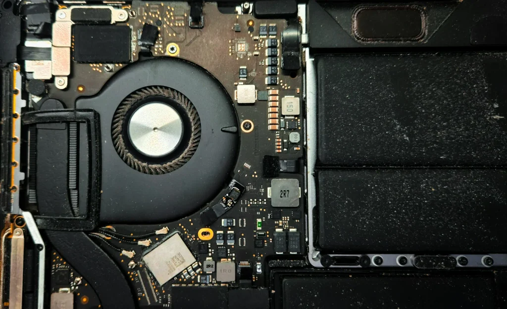 What Is a Hot CPU Temperature for a Laptop? Safe Ranges, Causes & Fixes (2026) 2 Inspecting a dusty laptop cooling fan to explain what is a hot CPU temperature for a laptop
